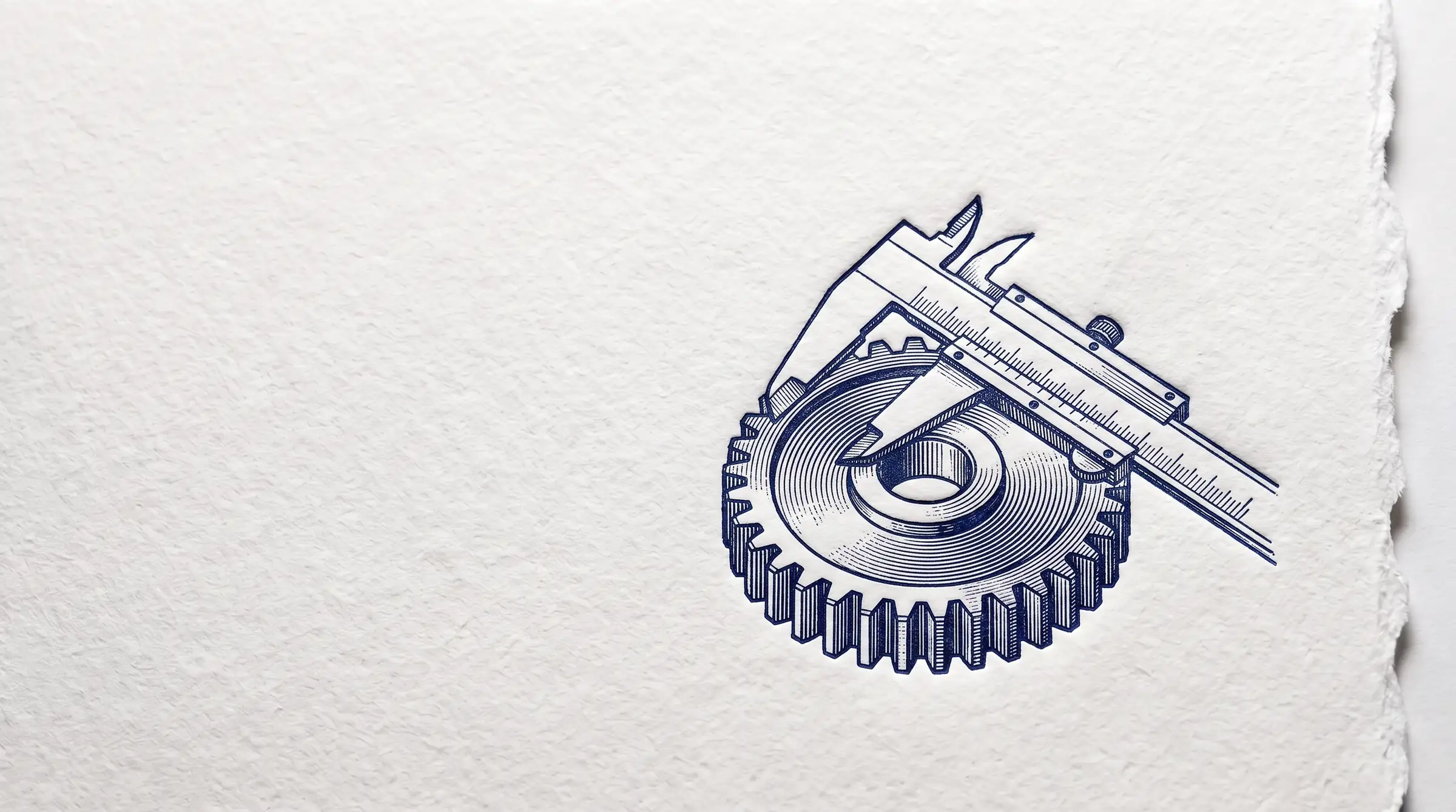 A letterpress print: a machined gear with a precision caliper resting across it, pressed in deep navy ink into thick white cotton paper with a deckled edge, lit from the side so the impression casts a soft shadow.